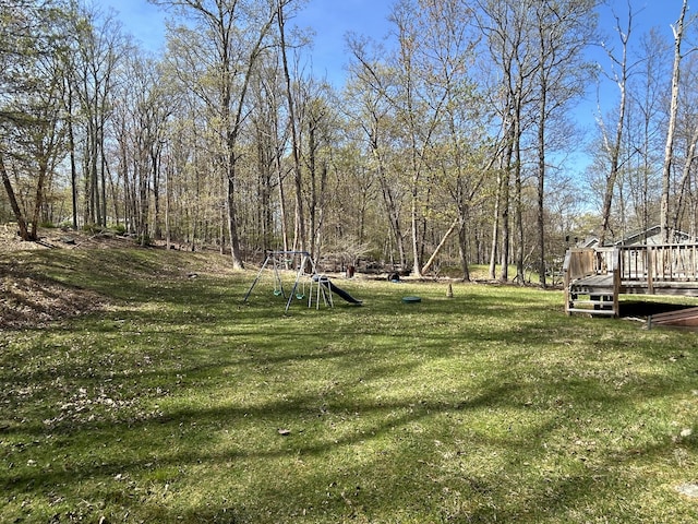 view of yard featuring a playground and a wooden deck