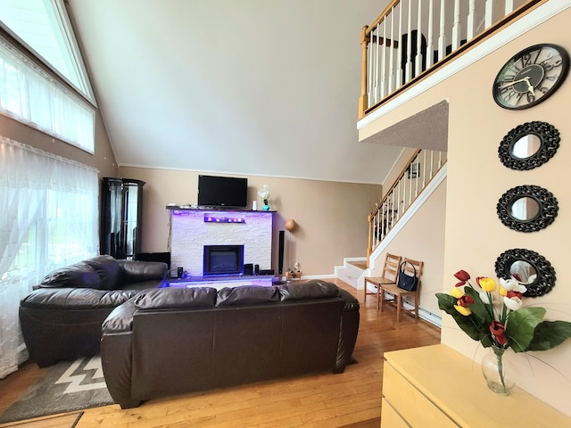 1025 Cricket Ln, Long Pond, PA 18334 - living area with high vaulted ceiling, light wood finished floors, a fireplace, and stairs