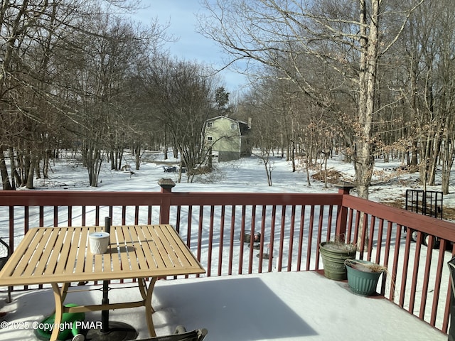 snow covered deck featuring outdoor dining area