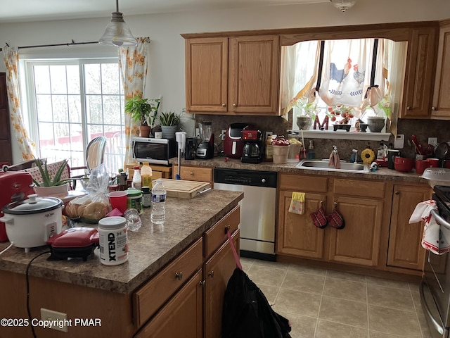 kitchen with stainless steel appliances, hanging light fixtures, dark countertops, and brown cabinets