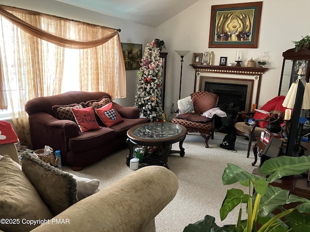 carpeted living room featuring a fireplace and vaulted ceiling