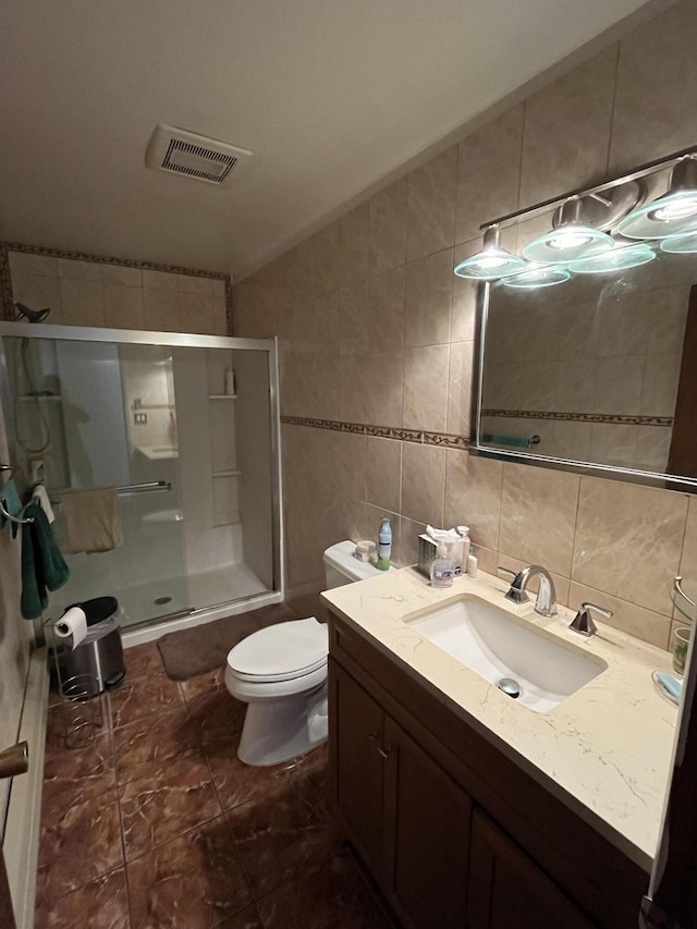 full bathroom with vanity, toilet, tile walls, a shower stall, and visible vents