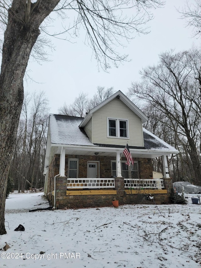 view of front of property featuring stone siding and a porch