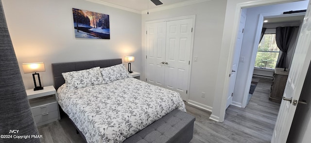 bedroom featuring a closet, baseboards, crown molding, and wood finished floors