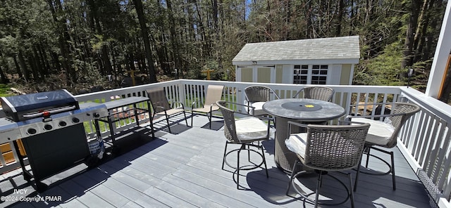 deck featuring a storage shed, outdoor dining space, and an outdoor structure