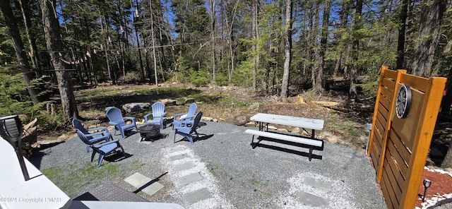 view of patio featuring a forest view and a fire pit