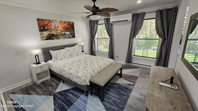 bedroom with ceiling fan, wood finished floors, baseboards, ornamental molding, and a wall mounted air conditioner