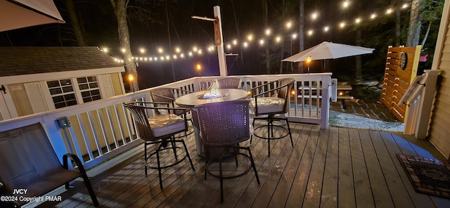 deck at twilight with outdoor dining area