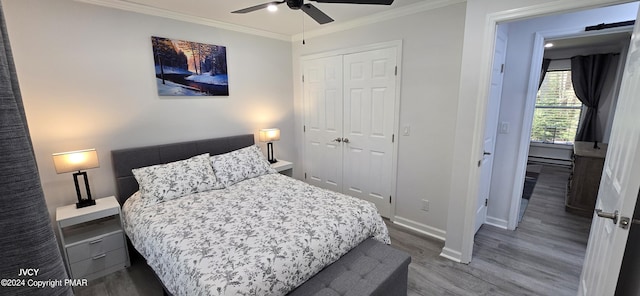 bedroom with ceiling fan, wood finished floors, baseboards, ornamental molding, and a closet