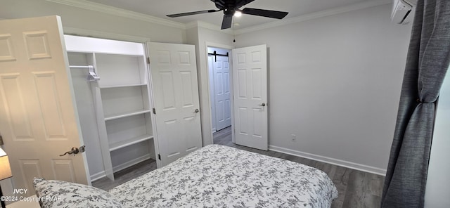 bedroom with dark wood-style flooring, crown molding, a barn door, a ceiling fan, and baseboards