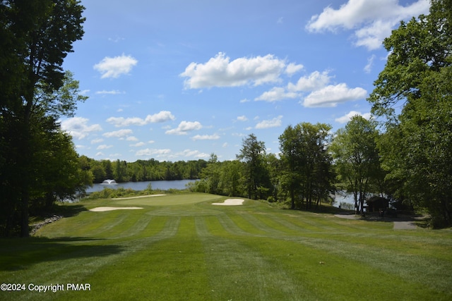 view of home's community featuring view of golf course, a water view, and a yard