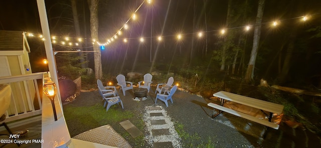 patio at night featuring an outdoor fire pit