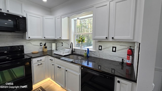 kitchen featuring a sink, white cabinetry, dark stone counters, black appliances, and tasteful backsplash