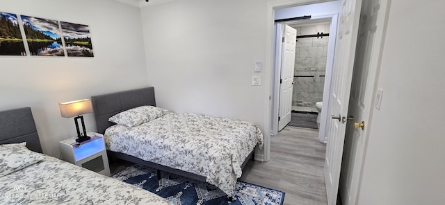 bedroom featuring connected bathroom and wood finished floors