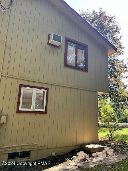 view of home's exterior with a wall unit AC