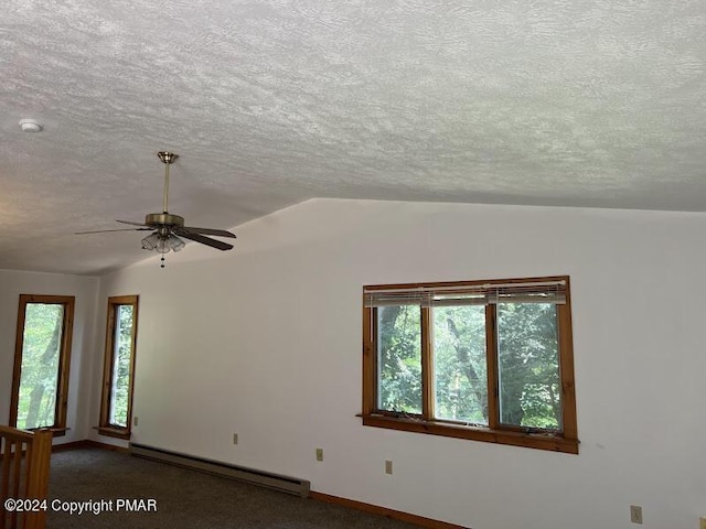 spare room featuring a baseboard heating unit, a textured ceiling, plenty of natural light, and lofted ceiling