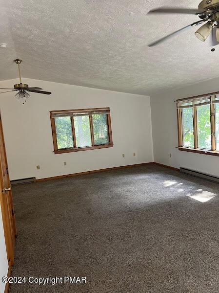 spare room featuring lofted ceiling, carpet, a baseboard radiator, and a ceiling fan