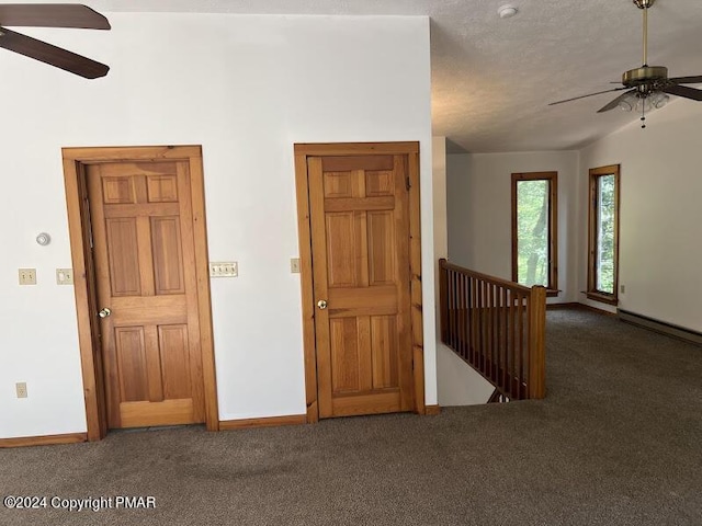 unfurnished room with a textured ceiling, carpet floors, a ceiling fan, and baseboards