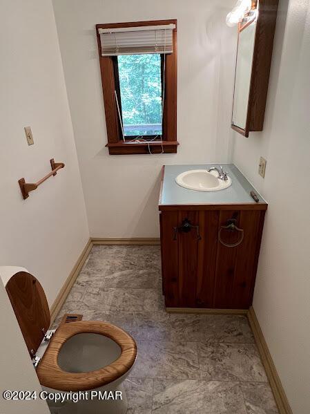 half bathroom featuring baseboards and vanity