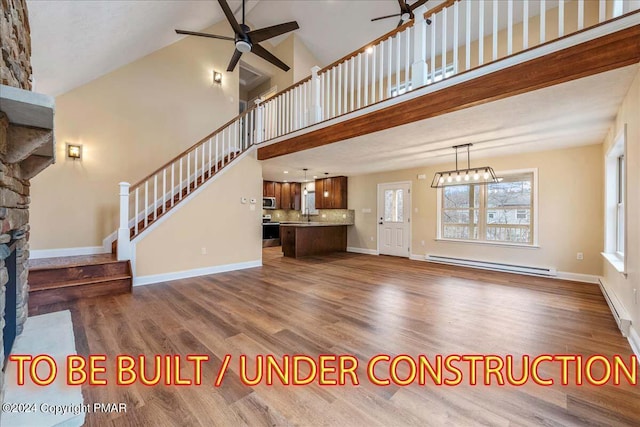84 Parker Trl, Albrightsville, PA 18210 - unfurnished living room featuring a ceiling fan, a fireplace, a high ceiling, baseboard heating, and dark wood-type flooring