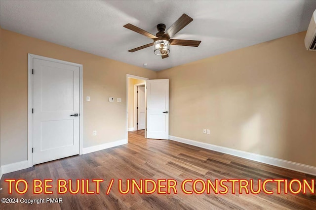 84 Parker Trl, Albrightsville, PA 18210 - unfurnished bedroom featuring a wall mounted AC, baseboards, ceiling fan, and wood finished floors