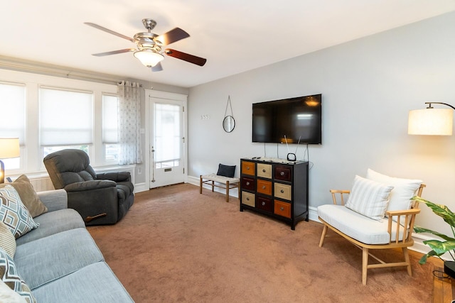 carpeted living room with baseboards and a ceiling fan