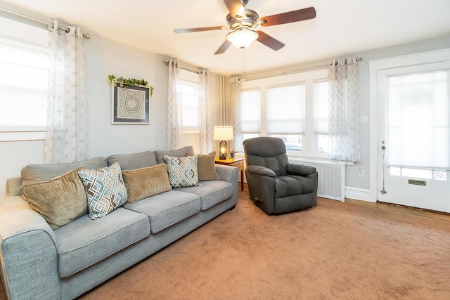 carpeted living room with baseboards and ceiling fan