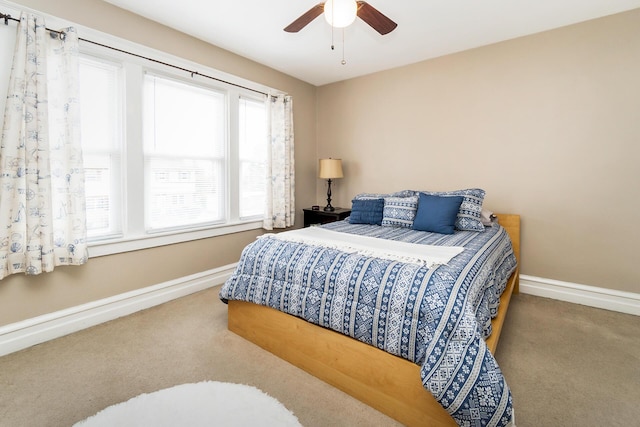 carpeted bedroom featuring baseboards and ceiling fan