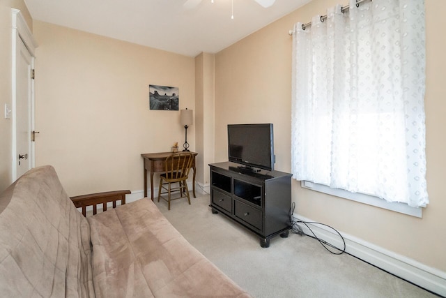 carpeted living area featuring baseboards and ceiling fan