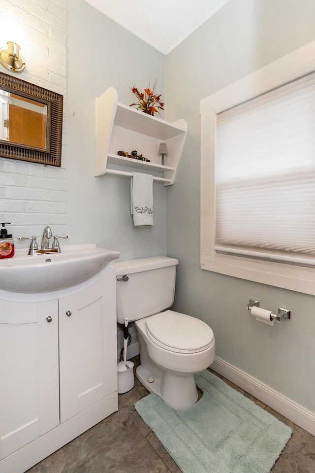 half bath with toilet, vanity, and baseboards