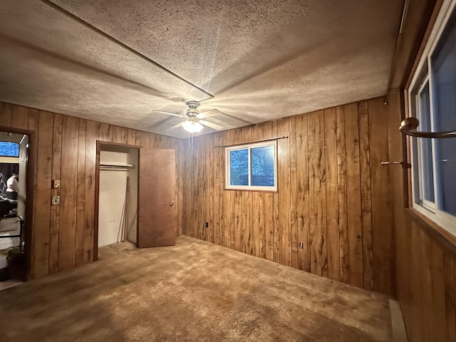 6069 Boardwalk Dr, Tobyhanna, PA 18466 - unfurnished bedroom with wood walls, carpet floors, ceiling fan, and a closet