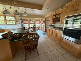 163 Wagner Blvd, Greenfield Township, PA 18407 - kitchen featuring stainless steel double oven, light tile patterned floors, tasteful backsplash, and a tray ceiling