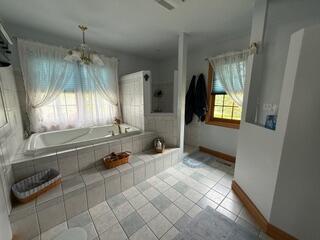 163 Wagner Blvd, Greenfield Township, PA 18407 - full bathroom with tiled bath, tile patterned flooring, baseboards, and a chandelier