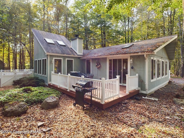 5310 Conoquenissing Dr, Pocono Lake, PA 18347 - rear view of house featuring a deck, roof with shingles, a chimney, and fence