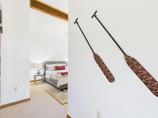 bedroom with beam ceiling, carpet, and baseboards