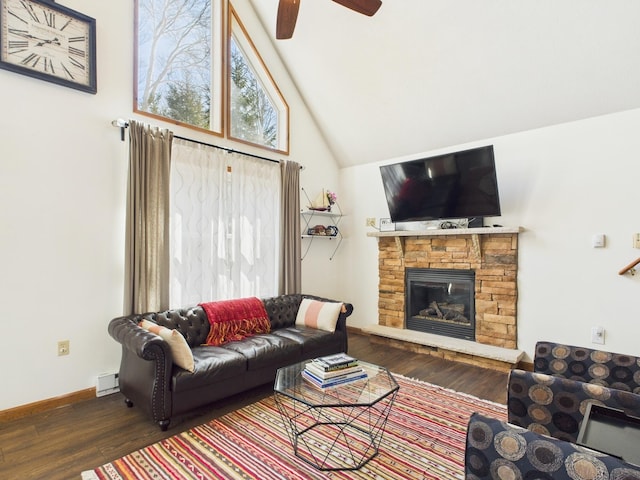 living area with high vaulted ceiling, a ceiling fan, wood finished floors, a fireplace, and baseboards