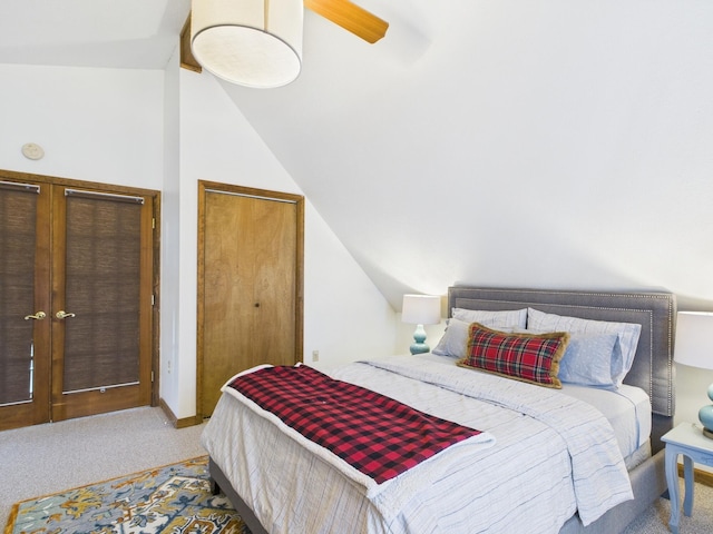 carpeted bedroom featuring vaulted ceiling and ceiling fan