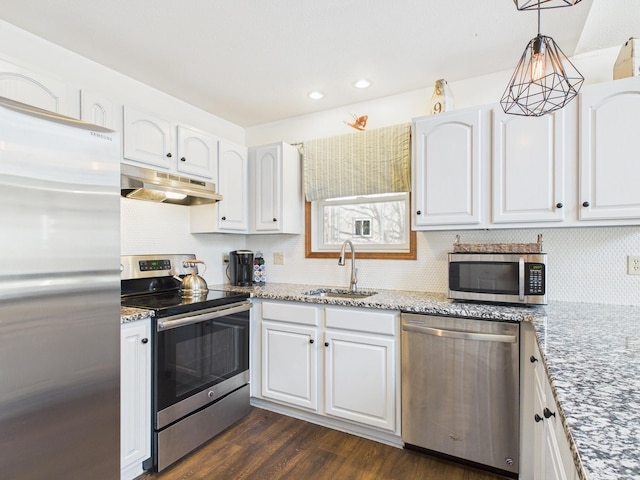 kitchen featuring a sink, under cabinet range hood, appliances with stainless steel finishes, white cabinets, and dark wood-style flooring