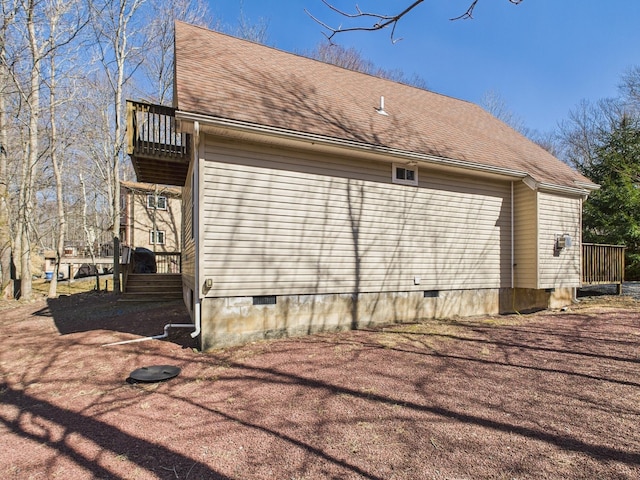 view of side of property with a balcony, roof with shingles, and crawl space