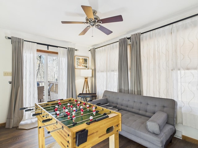 rec room featuring baseboards, a ceiling fan, and wood finished floors