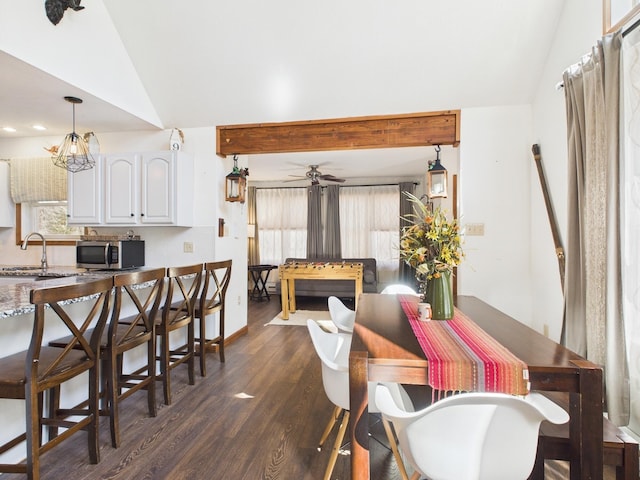 dining area with vaulted ceiling, a ceiling fan, and dark wood-style flooring