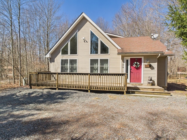 rustic home with a shingled roof and a deck