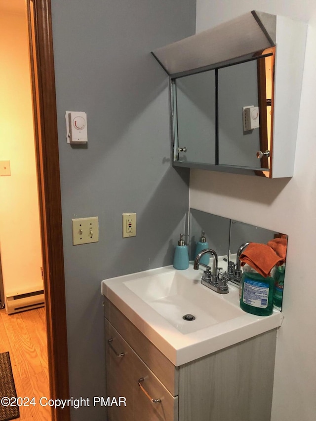 bathroom featuring a baseboard radiator, vanity, and wood finished floors