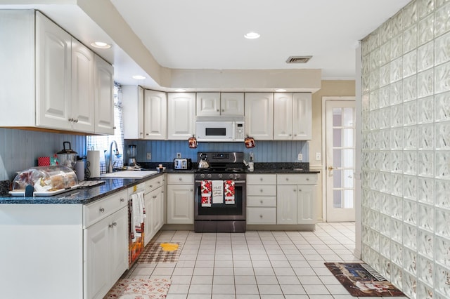 109 Little Doe Ln, East Stroudsburg, PA 18301 - kitchen with stainless steel range with gas stovetop, light tile patterned floors, white cabinetry, white microwave, and recessed lighting