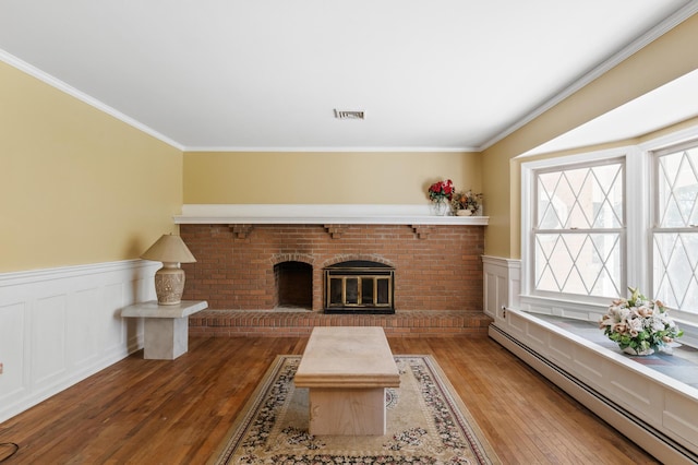 109 Little Doe Ln, East Stroudsburg, PA 18301 - living room featuring a baseboard radiator, hardwood / wood-style floors, wainscoting, a brick fireplace, and ornamental molding