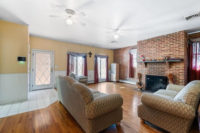109 Little Doe Ln, East Stroudsburg, PA 18301 - living area featuring a ceiling fan, a wainscoted wall, a brick fireplace, wood finished floors, and a baseboard heating unit