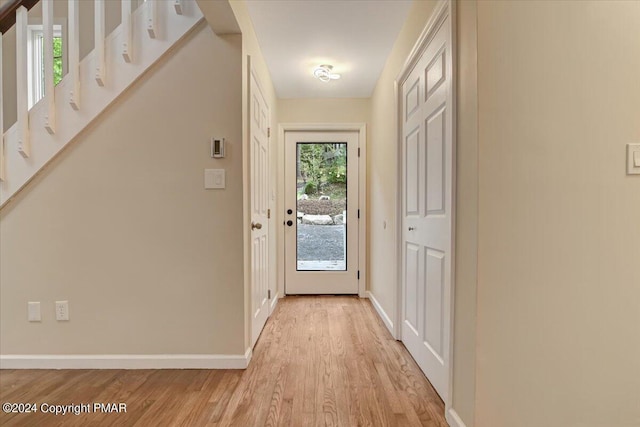 entryway with light wood-style flooring, a wealth of natural light, and baseboards