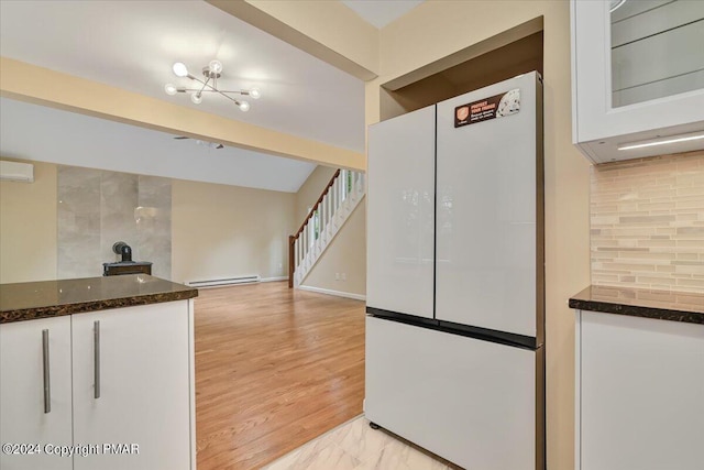 kitchen with beam ceiling, a baseboard radiator, backsplash, freestanding refrigerator, and white cabinets