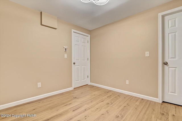 spare room featuring light wood finished floors and baseboards