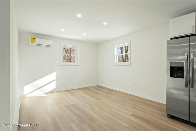 interior space featuring light hardwood / wood-style floors and an AC wall unit